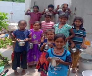 A photograph of ten children, holding nutrition drinks.