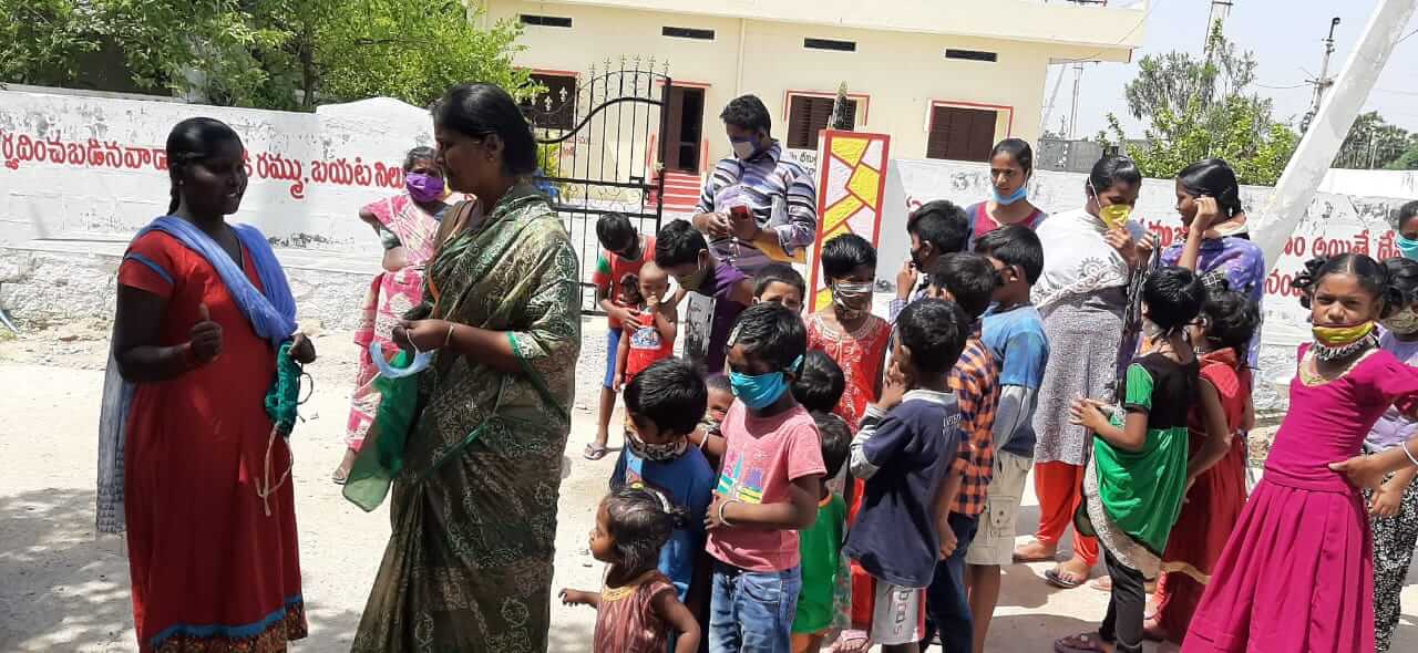 People talking in Nalgonda, with many children present.