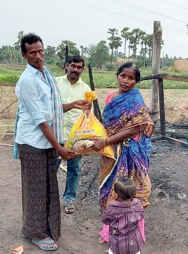 A family receiving rations amidst the ruins of their home.